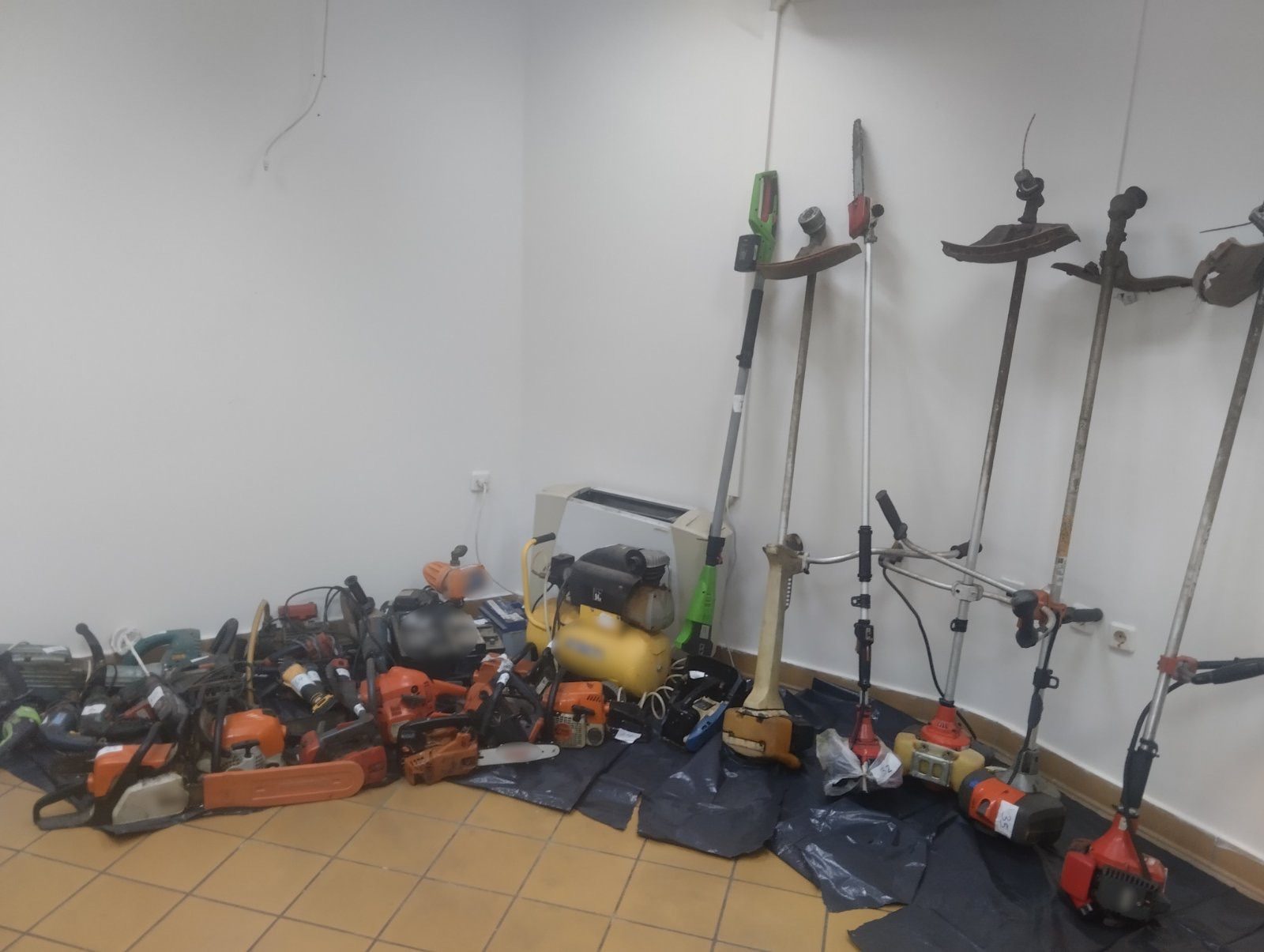Σωρός από κατασχεθέντα εργαλεία, όπως αλυσοπρίονα και χορτοκοπτικ…