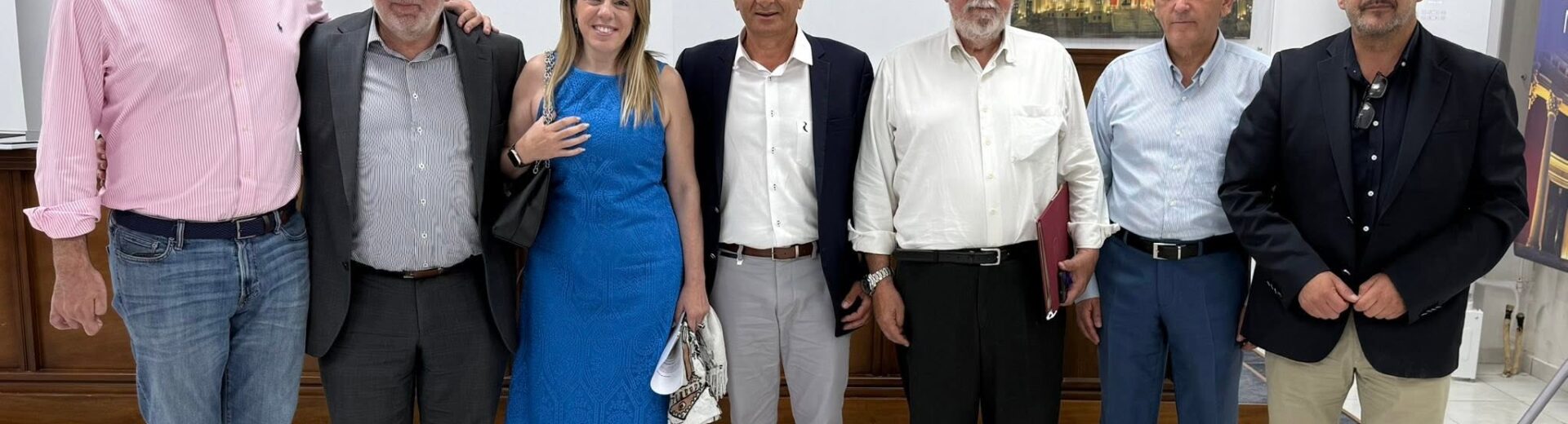 Επτά άτομα, έξι άνδρες και μία γυναίκα, ποζάρουν χαμογελαστοί σε εσ…