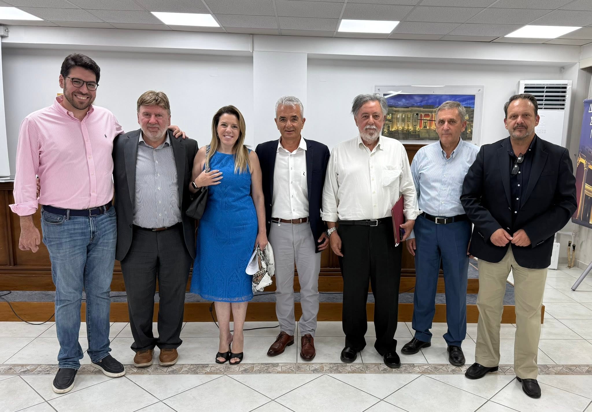 Επτά άτομα, έξι άνδρες και μία γυναίκα, ποζάρουν χαμογελαστοί σε εσ…
