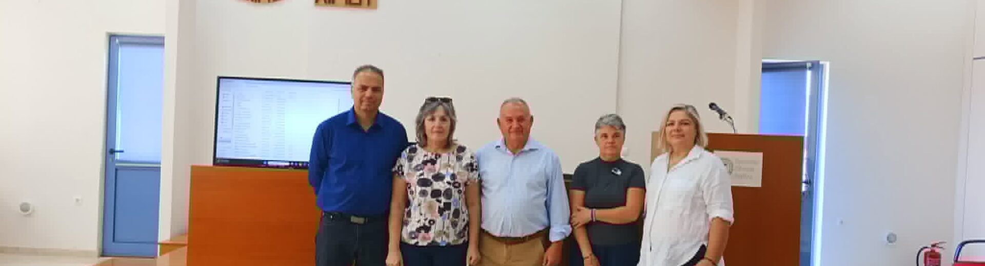 Πέντε άτομα ποζάρουν μπροστά στην πινακίδα του Εργατοϋπαλληλικού …