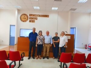Πέντε άτομα ποζάρουν μπροστά στην πινακίδα του Εργατοϋπαλληλικού …