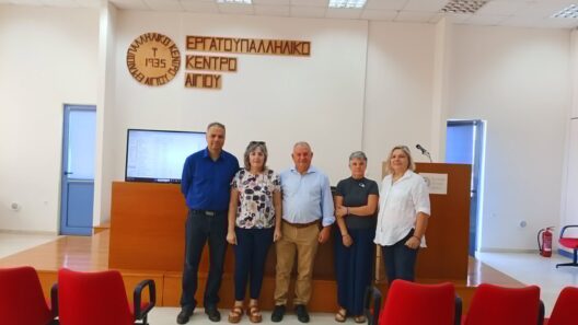 Πέντε άτομα ποζάρουν μπροστά στην πινακίδα του Εργατοϋπαλληλικού …