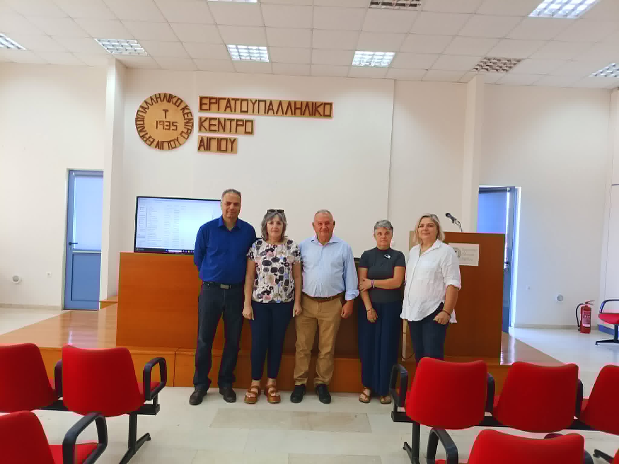 Πέντε άτομα ποζάρουν μπροστά στην πινακίδα του Εργατοϋπαλληλικού …