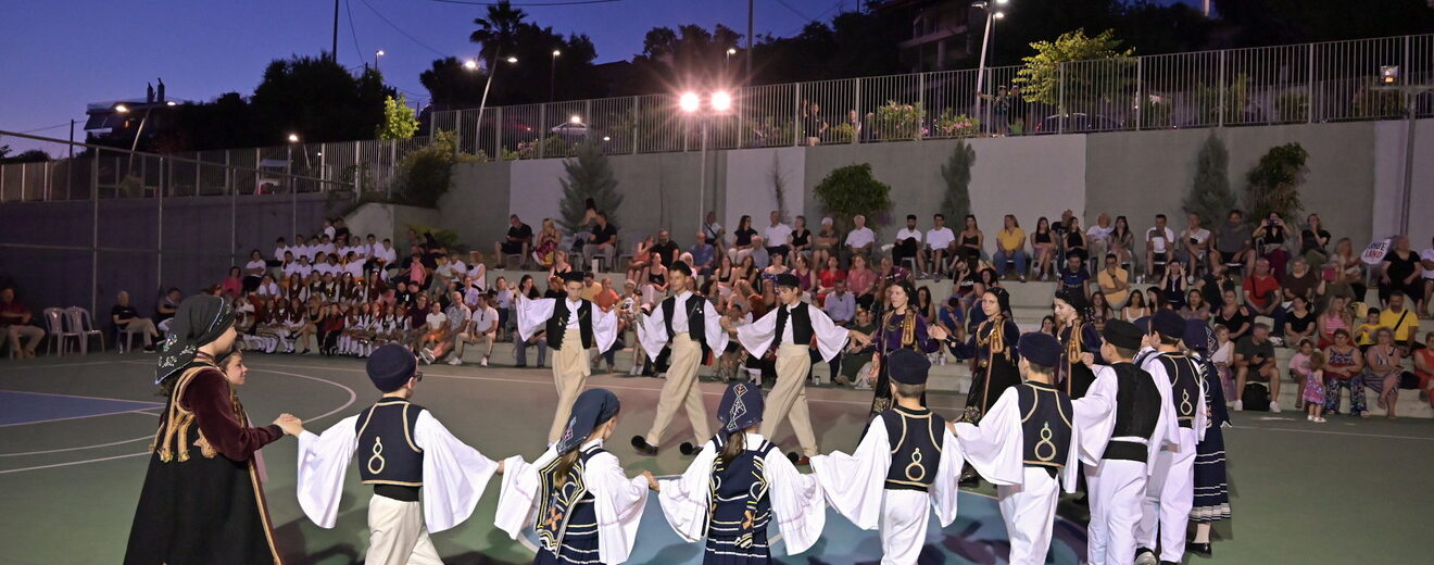 Παιδιά και έφηβοι με παραδοσιακές ελληνικές ενδυμασίες χορεύουν σ…