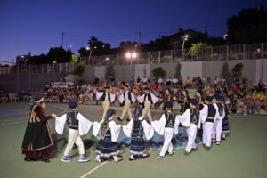 Παιδιά και έφηβοι με παραδοσιακές ελληνικές ενδυμασίες χορεύουν σ…