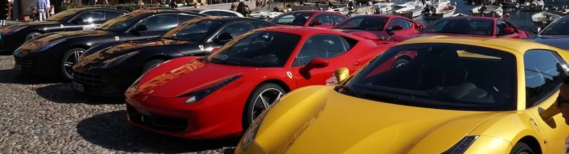 Σειρά από πολυτελείς Ferrari, κόκκινες, κίτρινες και μαύρες, παρκαρισμ…