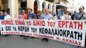 Διαδηλωτές κρατούν πανό με σύνθημα υπέρ των εργατών, στην Αχαΐα.