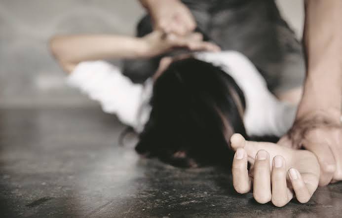 Χέρι συγκρατεί άτομο στο πάτωμα, απεικονίζοντας βία.