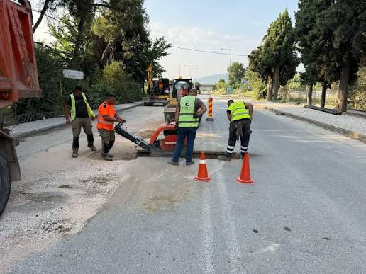 Εργάτες οδοποιίας με ανακλαστικά γιλέκα χρησιμοποιούν μηχανήματα…