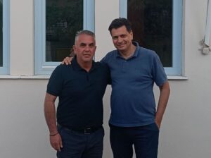 Ο Δήμαρχος Ιθάκης Διονύσης Στανίτσας και ένας άνδρας χαμογελούν.