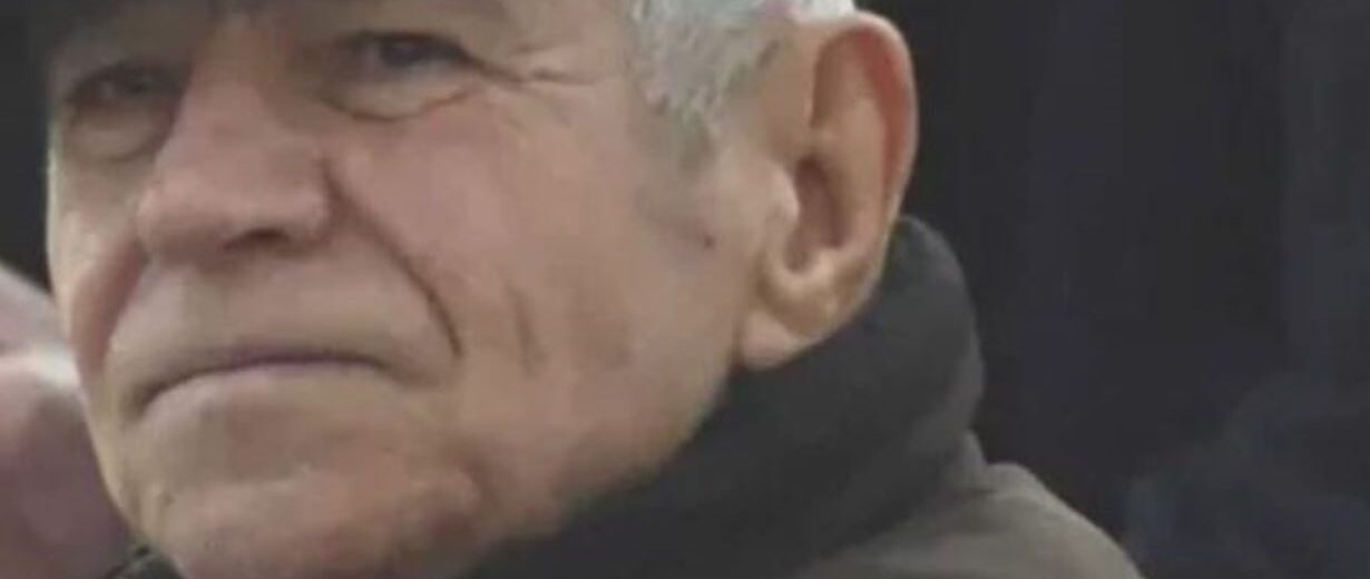Ο Θανάσης Τσιμιγκάτος, ηλικιωμένος άνδρας με γκρίζα μαλλιά και σκο…