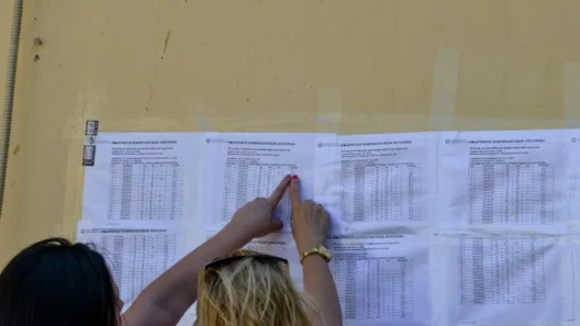 Γυναίκες εξετάζουν αναρτημένες βαθμολογίες Πανελληνίων, με το δάχ…