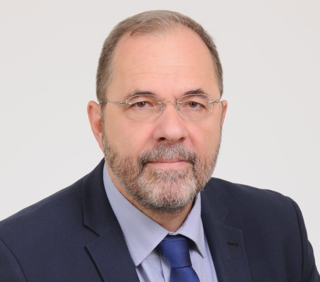 Πορτρέτο άνδρα με γένια, γυαλιά, σκούρο μπλε κοστούμι και μπλε γραβ…