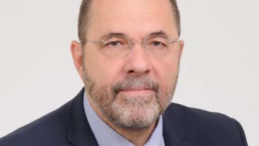 Πορτρέτο άνδρα με γένια, γυαλιά, σκούρο μπλε κοστούμι και μπλε γραβ…