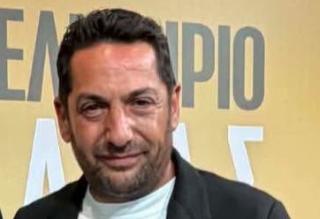 Πορτρέτο άνδρα με σκούρα μαλλιά και γένια, φορώντας σκούρο σακάκι, …