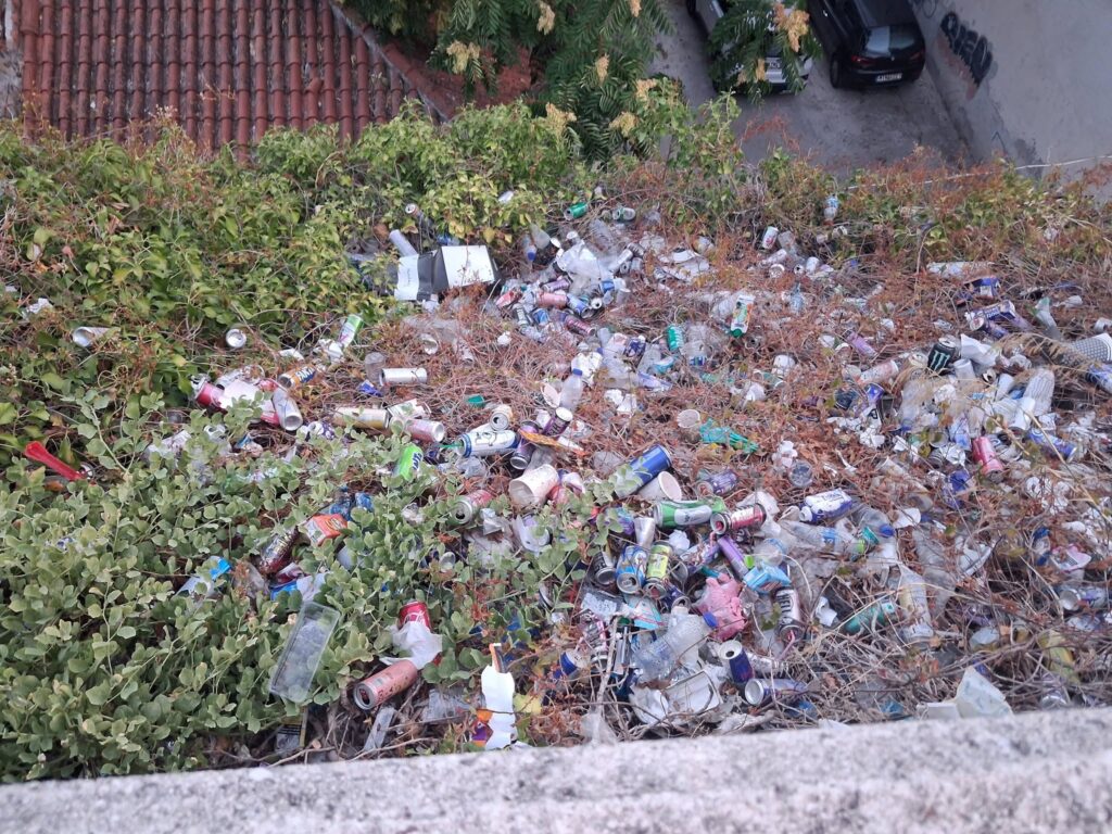 Μεγάλος σωρός από πλαστικά μπουκάλια και κουτάκια αναψυκτικών πετ…