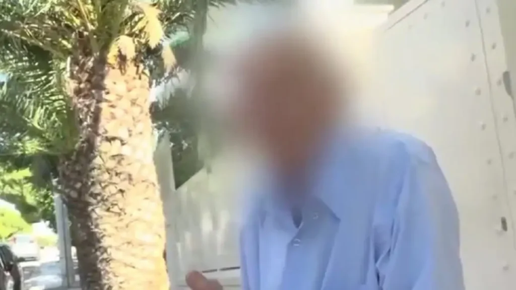 Ένας θολός ηλικιωμένος άνδρας με γαλάζιο πουκάμισο, δίπλα σε φοίνι…