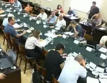 Συνεδρίαση του Δημοτικού Συμβουλίου Πάτρας με μέλη γύρω από ένα μα…