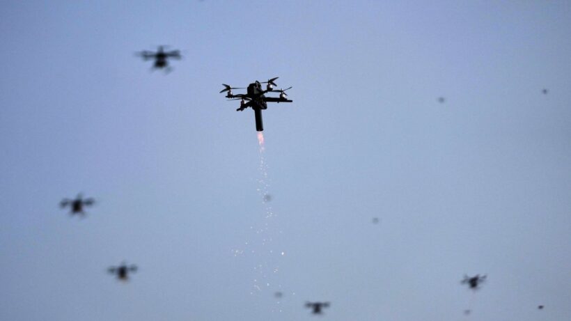 Ένα drone εκτοξεύει φλόγες και σπίθες στον ουρανό, με άλλα drones στο βάθ…