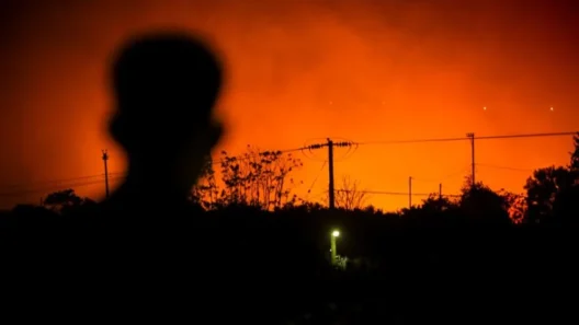 LIVE - Ολονύκτια μάχη με τις φλόγες στο Ωραιόκαστρο και Φιλοθέη Θεσσαλονίκης - Καίγομαι σπίτια και εργοστάσια 37 Σκοτεινή σιλουέτα ανθρώπου με φόντο έναν πορτοκαλοκόκκινο ουρανό …