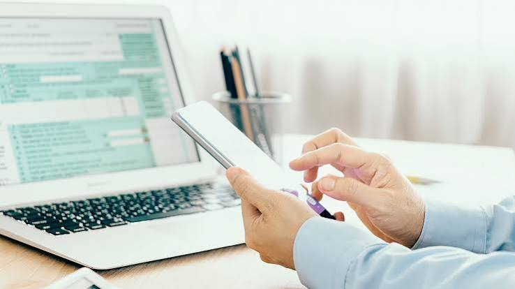 Συμπλήρωση φορολογικής δήλωσης σε laptop, με ταυτόχρονη χρήση smartphone.