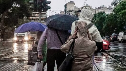 Αχαΐα: Τέλος στον μίνι καύσωνα με απότομη αλλαγή του καιρού 18 Άνθρωποι με ομπρέλες περπατούν σε βροχερό δρόμο πόλης.