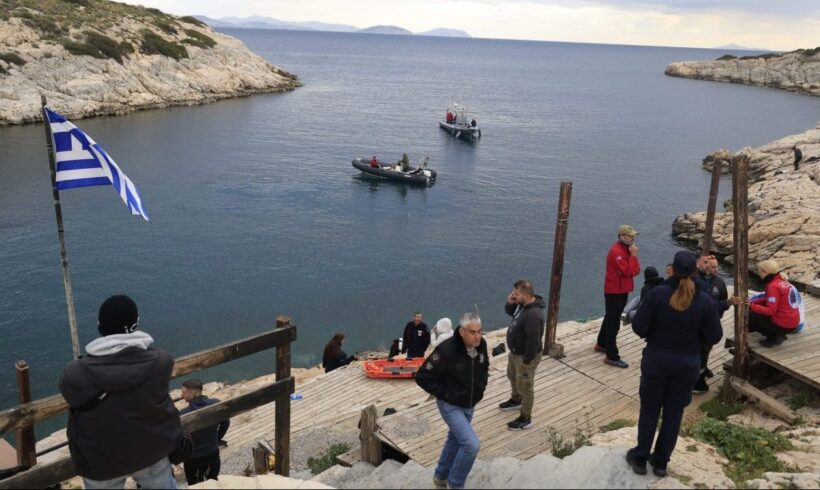 Αιγαίο: Θρίλερ με σορούς άνδρα και ανηλίκου 4 Άποψη βραχώδους κόλπου με ελληνική σημαία, σκάφη και ομάδες διάσωσ…