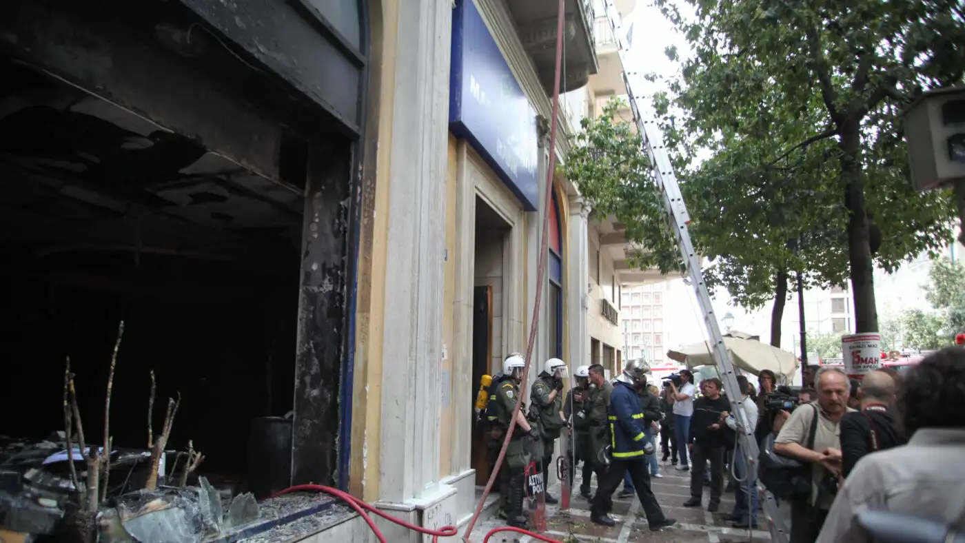 Καμένο κτίριο της Marfin Bank με αστυνομία, πυροσβέστες και πλήθος στον …