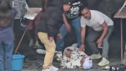 Άνθρωποι σκύβουν πάνω από ένα θύμα ένοπλης επίθεσης που κείτεται σ…