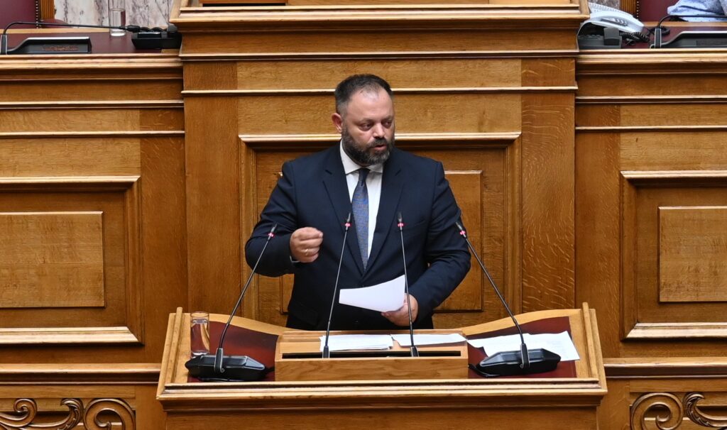Άδωνις Γεωργιάδης μιλάει από το βήμα της Βουλής, φορώντας κοστούμι…