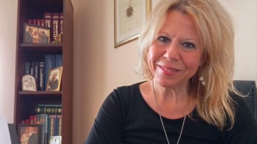 «Μια τεράστια πινακίδα που έχει το σήμα της Περιφέρειας Δυτικής Ελλάδος» 13 Χαμογελαστή ξανθιά γυναίκα με μαύρη μπλούζα και ασημένιο κολιέ, κο…