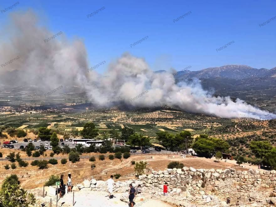 Πυκνός καπνός από δασική πυρκαγιά υψώνεται πάνω από λόφους με βλάσ…