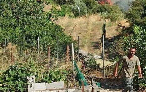 Αιγιάλεια: Αλληλεγγύη σε πυροσβέστες και εθελοντές από το Διακοπτό με συγκέντρωση ειδών πρώτης ανάγκης 17 Άνδρας περπατά με φωτιά και καπνό σε λόφο στο βάθος.