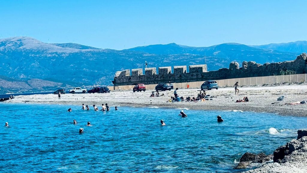 Άνθρωποι κολυμπούν και χαλαρώνουν σε παραλία στο Ρίο, με βότσαλα, π…