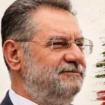 Άνδρας με γκρίζα γένια και γυαλιά, με φόντο το κέδρο του Λιβάνου.