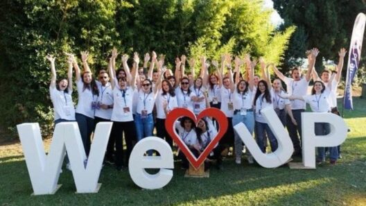 Τον Οκτώβριο το Welcome UP 2026 του Πανεπιστήμιο Πατρών ΦΩΤΟ 12 Ομάδα νέων με λευκά μπλουζάκια πανηγυρίζει μπροστά στις λέξεις "WE U…