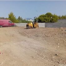 Κατασκευή χώρου στάθμευσης με κόκκινο βαν και κίτρινο οδοστρωτήρα…