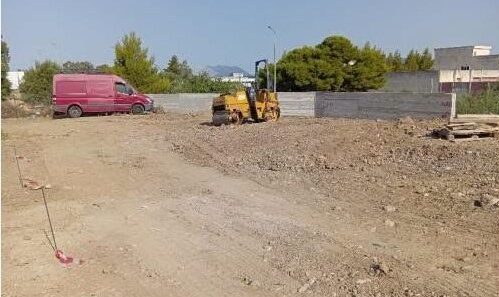 Κατασκευή χώρου στάθμευσης με κόκκινο βαν και κίτρινο οδοστρωτήρα…
