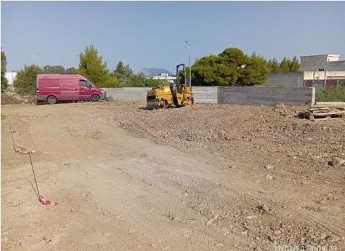 Κατασκευή χώρου στάθμευσης με κόκκινο βαν και κίτρινο οδοστρωτήρα…