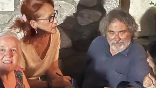 Γυναίκα με γυαλιά κρατάει στυλό, ενώ ένας άνδρας με γένια κοιτάζει …