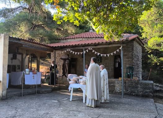 Ιερείς τελούν λειτουργία σε εξωκλήσι, με άρτους ευλογίας σε τραπέζι.