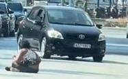 Πάτρα: Γυναίκα ξάπλωσε στη μέση του δρόμου προκαλώντας αναστάτωση ΦΩΤΟ 3 Ένα άτομο κάθεται στο οδόστρωμα καθώς ένα μαύρο Toyota Auris περνάει.