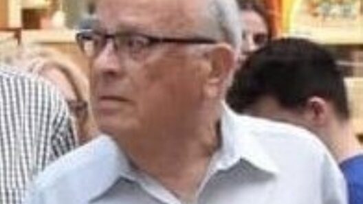 Ο γιατρός Γεράσιμος Ρηγόπουλος φοράει γυαλιά και ανοιχτόχρωμο που…