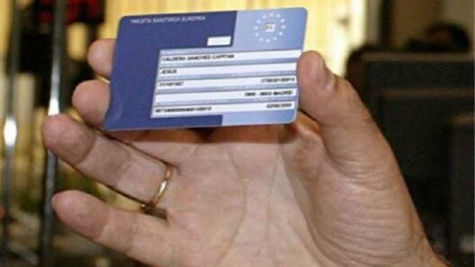 Ένα χέρι κρατά μια Ευρωπαϊκή Κάρτα Υγείας, σχετική με απάτη μέσω email.