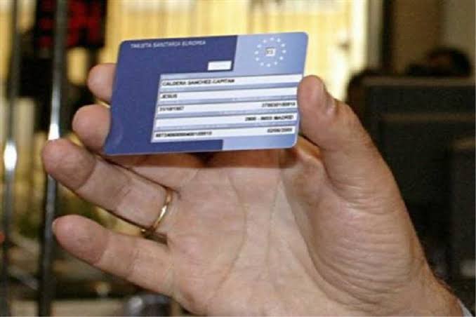 Ένα χέρι κρατά μια Ευρωπαϊκή Κάρτα Υγείας, σχετική με απάτη μέσω email.