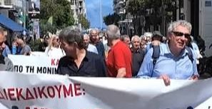 Διαδηλωτές κρατούν πανό σε πορεία στην Αιγιάλεια, ζητώντας άμεση λ…
