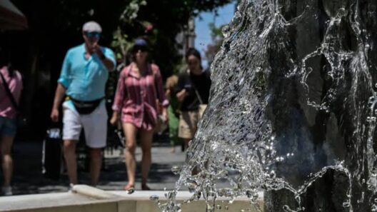 Νερό αναβλύζει από σιντριβάνι σε ηλιόλουστο τοπίο, με ανθρώπους να…
