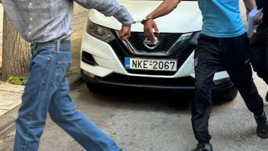 Ζαχάρω: Απ' όλα είχε ο «μπαξές» και συνελήφθησαν τρεις 13 Άνδρας με χειροπέδες οδηγείται από άλλον άνδρα μπροστά σε λευκό αυ…