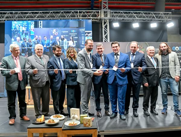 Εγκαίνια έκθεσης αγροδιατροφής με αξιωματούχους να κόβουν κορδέλα.