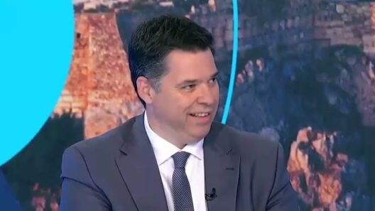 Ο Υφυπουργός Θανάσης Κοντογεώργης χαμογελά φορώντας κοστούμι και …